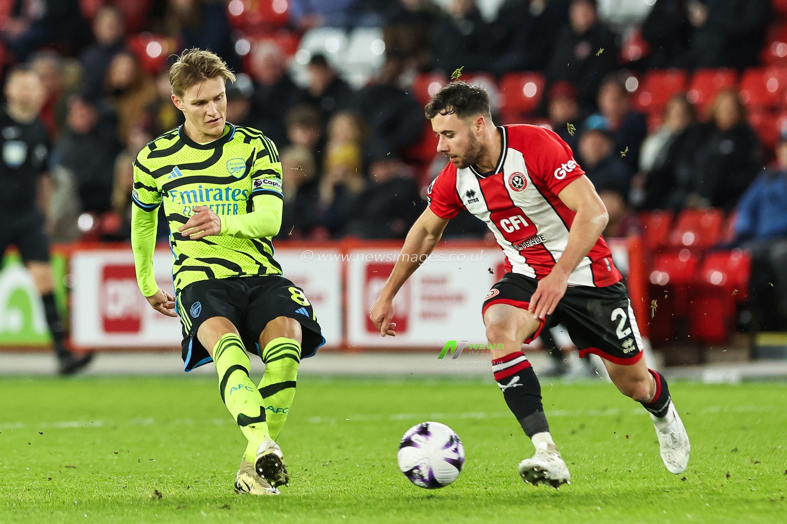 Martin Ã˜degaard of Arsenal passes the ball despite pressure from George Baldock of Sheffield United during the Premier League match Sheffield United vs Arsenal at Bramall Lane, Sheffield, United Kingdom, 4th March 2024

(Photo by Mark Cosgrove/News Images)