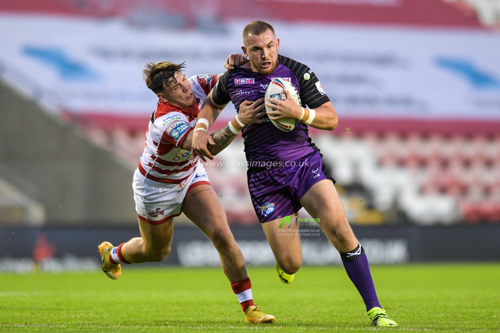 Keanan Brand (24) of Leigh Centurions attempts to tackle Cameron Smith (17) of Leeds Rhinos