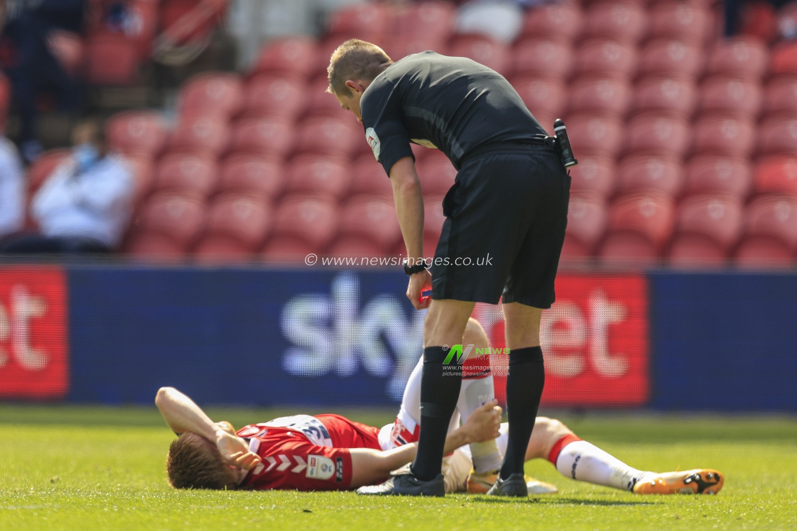 Referee Matthew Donohue checks on Duncan Watmore #18 of Middlesbrough after the player was fouled by Seny Dieng #13 of Queens Park Rangers, who was sent off for the foul