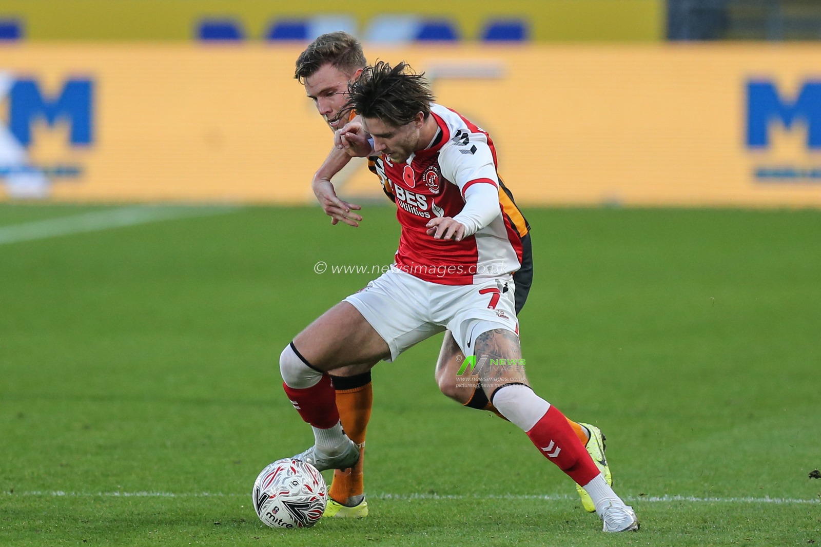 Wes Burns #7 of Fleetwood Town and Callum Elder #3 of Hull City challenge for the ball