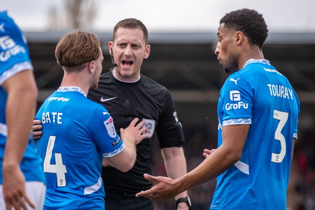 Referee Simon Mather speaks to Stockport County players after awarding Wrexham a first half penalty during the Sky Bet League 1 match Wrexham vs Stockport County at SToK Cae Ras, Wrexham, United Kingdom, 22nd March 2025

(Photo by Nik Mesney/News Images)