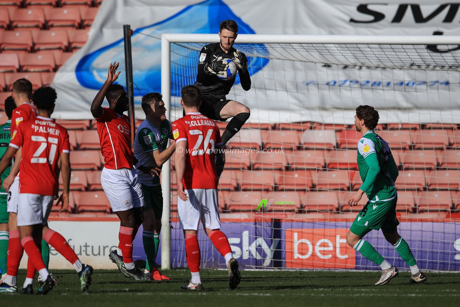 Bradley Collins #40 of Barnsley gets up high to catch the ball