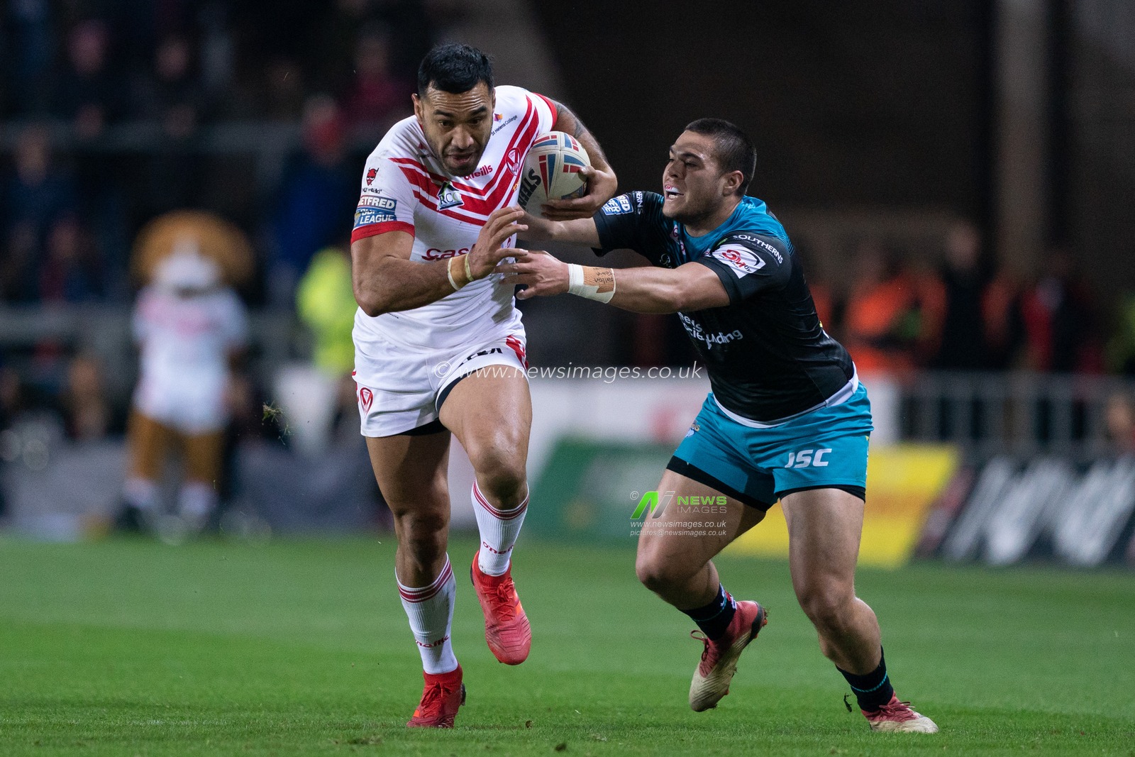 St. Helens's Zeb Taia is tackled by Leeds Rhinos's Tu'imoala Lolohea



22nd February 2019 , Totally Wicked Stadium, St Helens, England;  Betfred Super League, Round 3, St Helens vs Leeds Rhinos

Credit: Terry Donnelly/News Images