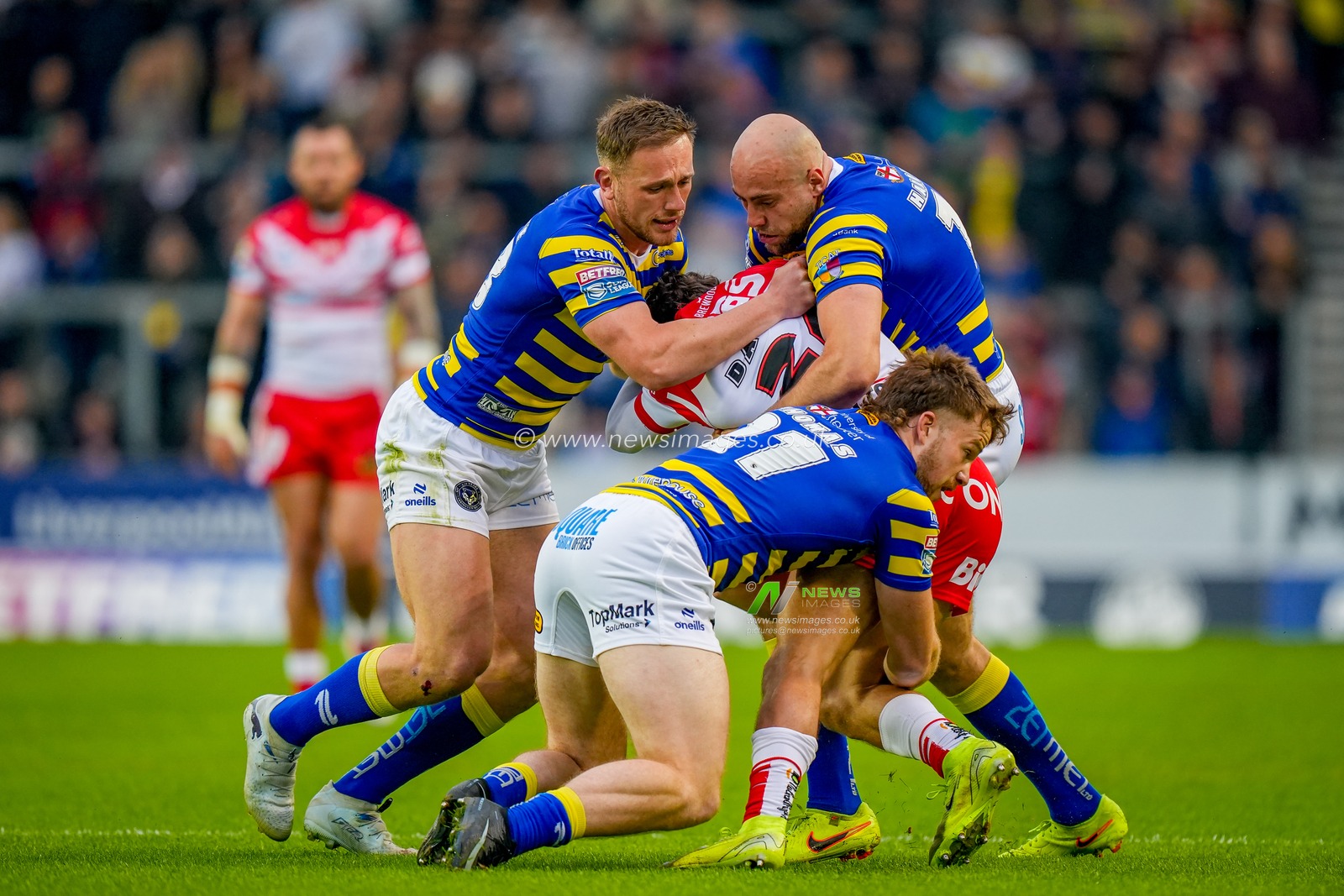James Harrison of Warrington Wolves and Luke Thomas of Warrington Wolves tackle Jake Burns of St Helens R.F.C. during the Betfred Super League round 14 match St Helens vs Warrington Wolves at The BrewDog Stadium, St Helens, United Kingdom on 11 June 2026

(Photo by Maynard Manyowa/News Images)