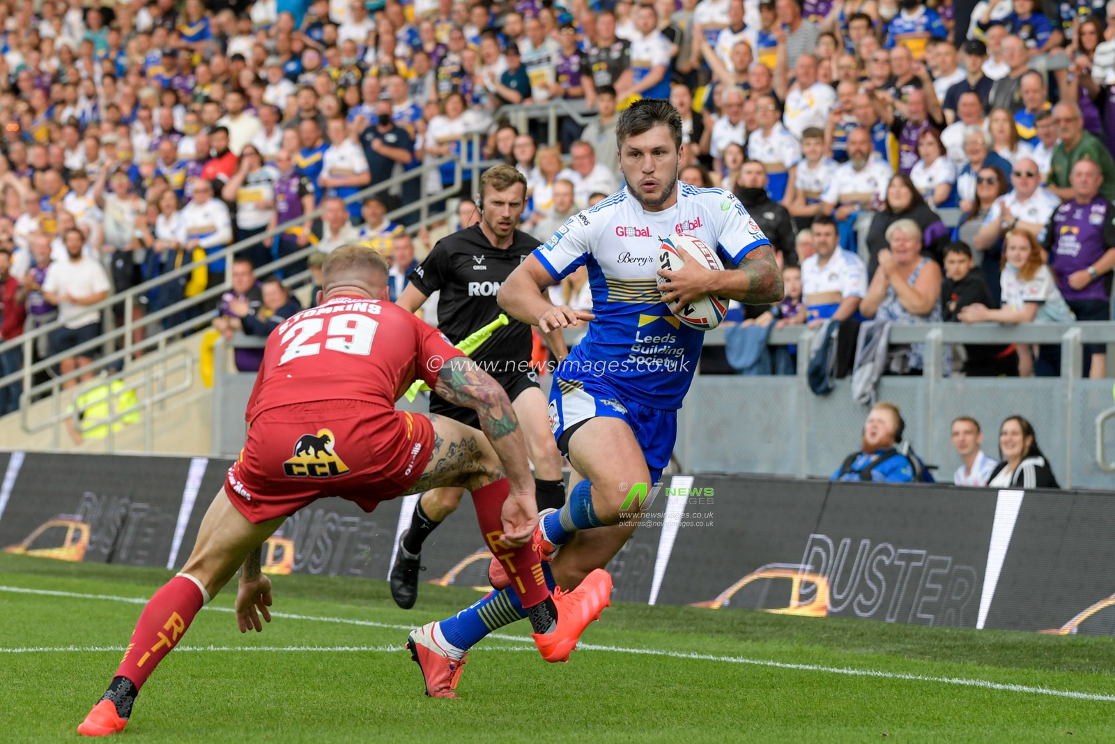 Tom Briscoe (2) of Leeds Rhinos looks for a way past Sam Tomkins (29) of Catalans Dragons