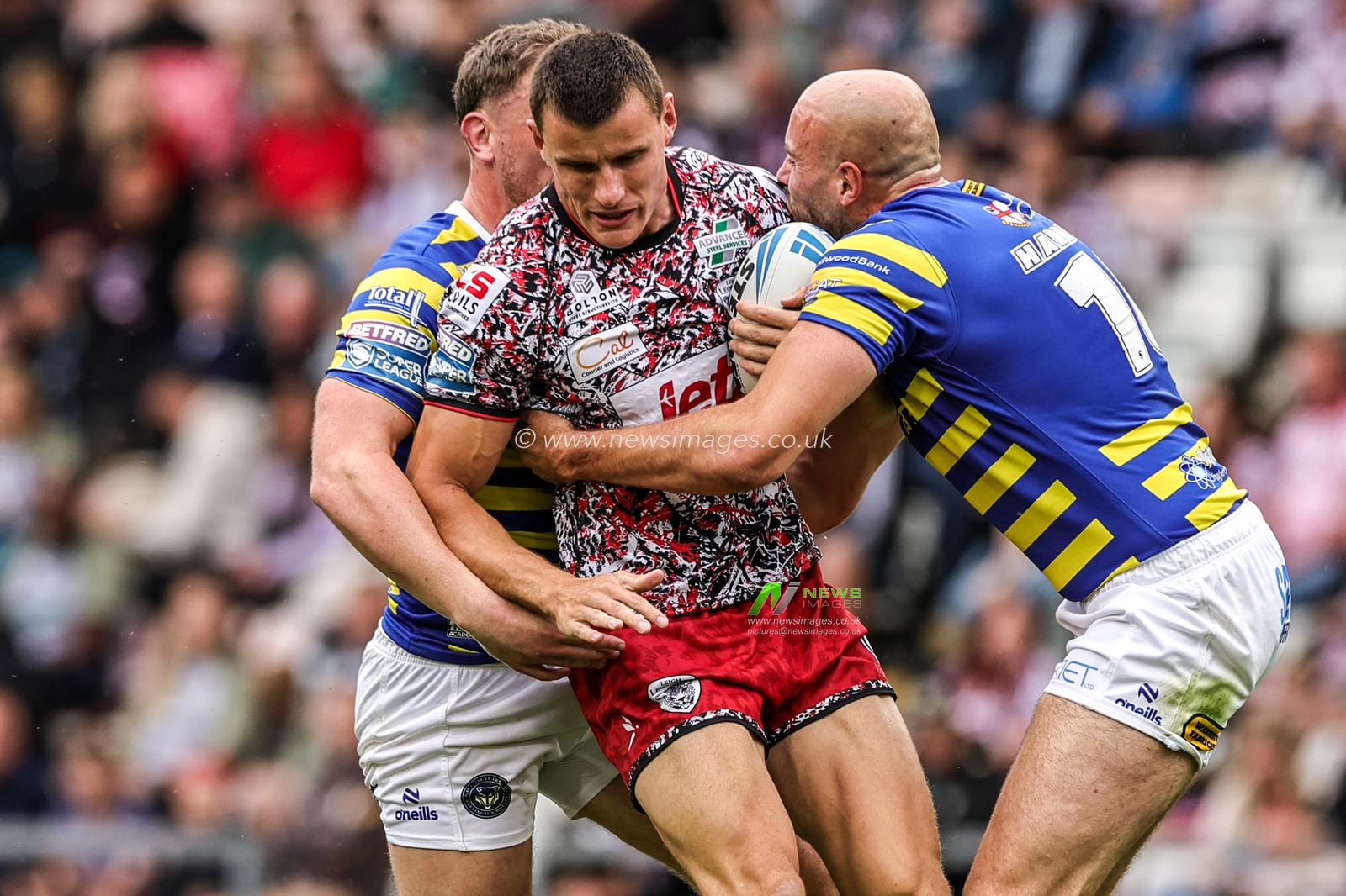 Innes Senior of Leigh Leopards is tackled by James Harrison of Warrington Wolves and Ben Currie of Warrington Wolves during the Betfred Super League round 20 match Leigh Leopards vs Warrington Wolves at Leigh Sports Village, Leigh, United Kingdom on 25 July 2026

(Photo by Alfie Cosgrove/News Images)