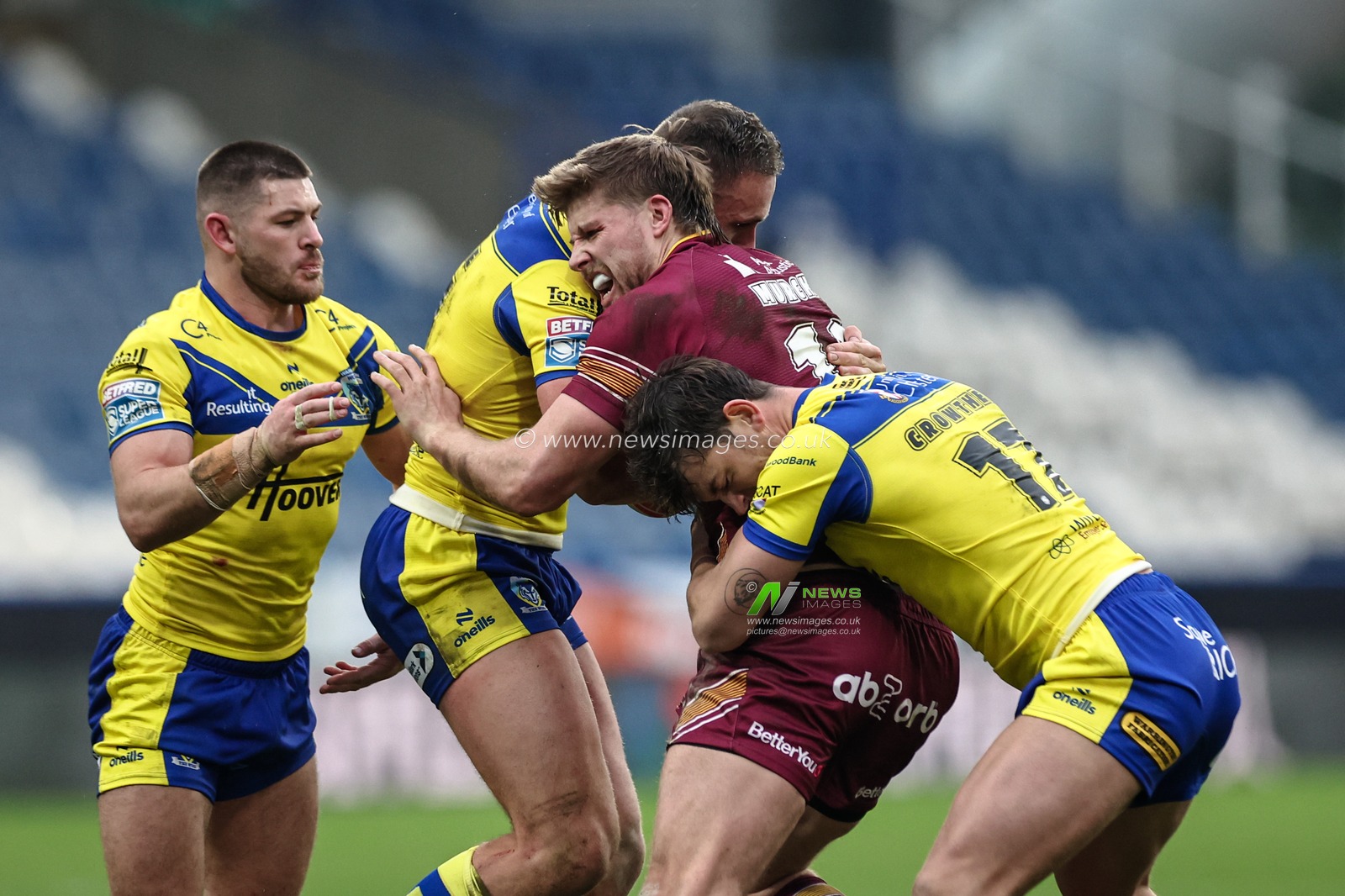 Jack Murchie of Huddersfield Giants is tackled by Ben Currie and Jordy Crowther of Warrington Wolves  during the Betfred Super League Round 1 match Huddersfield Giants vs Warrington Wolves at John Smith's Stadium, Huddersfield, United Kingdom, 16th February 2025

(Photo by Mark Cosgrove/News Images)