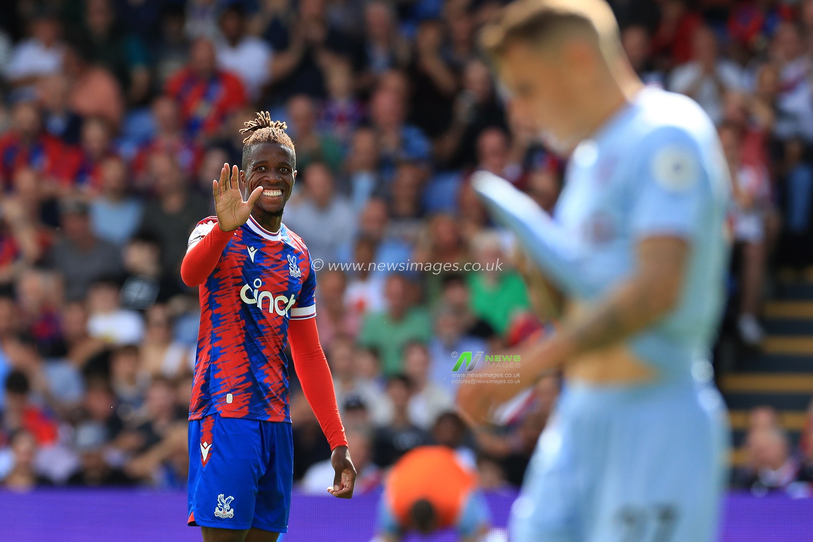 Wilfried Zaha of Crystal Palace apologises for an errant pass.