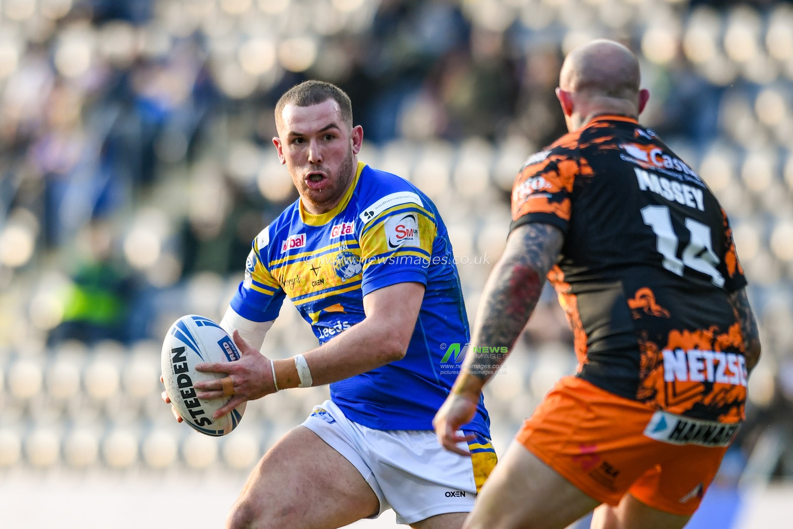 Cameron Smith #17 of Leeds Rhinos looks for a way past Nathan Massey #14 of Castleford Tigers