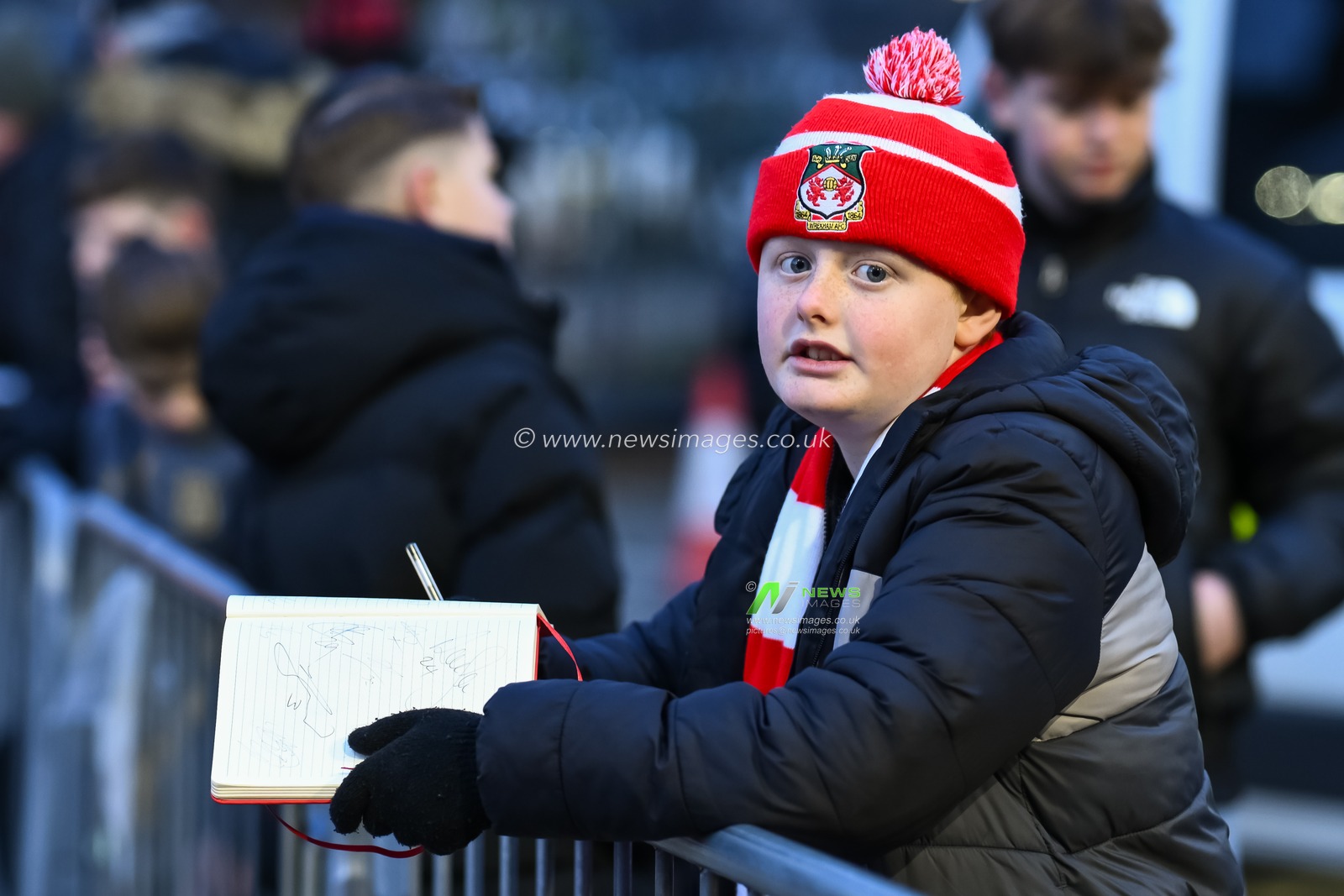 A young fans waits for players to arrive with his autograph book and pen in hand during the Sky Bet League 1 match Wrexham vs Leyton Orient at SToK Cae Ras, Wrexham, United Kingdom, 18th February 2025

(Photo by Craig Thomas/News Images)