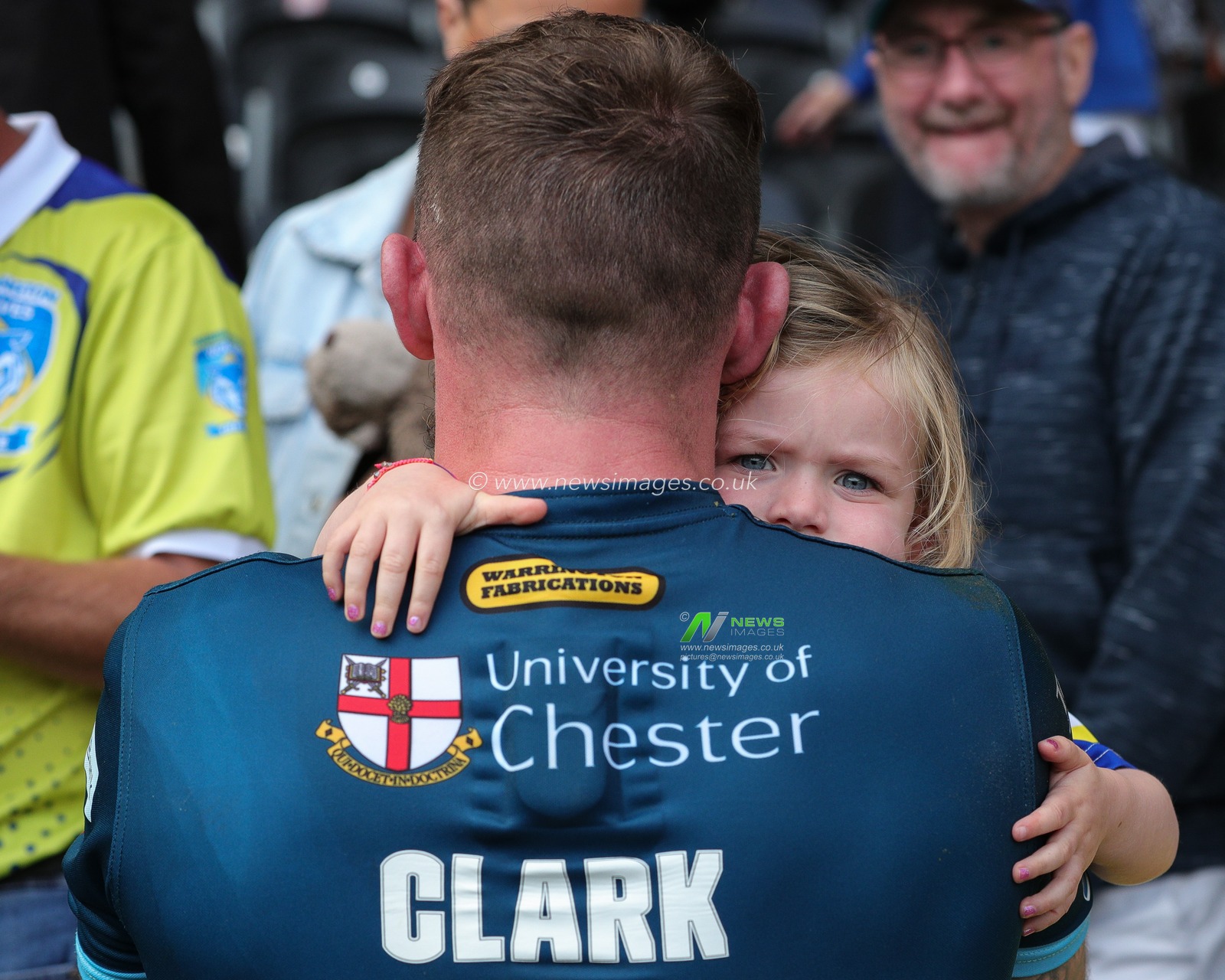 The daughter of Daryl Clark #9 of Warrington Wolves peaks over his shoulder after the Betfred Super League Round 23 match Hull FC vs Warrington Wolves at MKM Stadium, Hull, United Kingdom, 26th August 2023

(Photo by James Heaton/News Images)