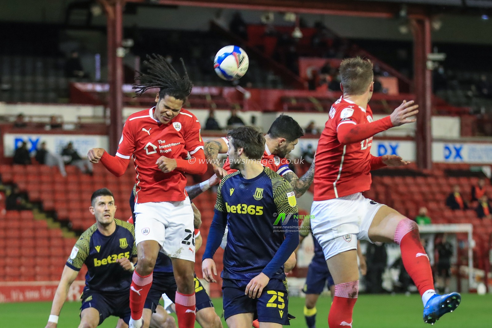 Toby Sibbick #20 of Barnsley heads clear from a Stoke corner