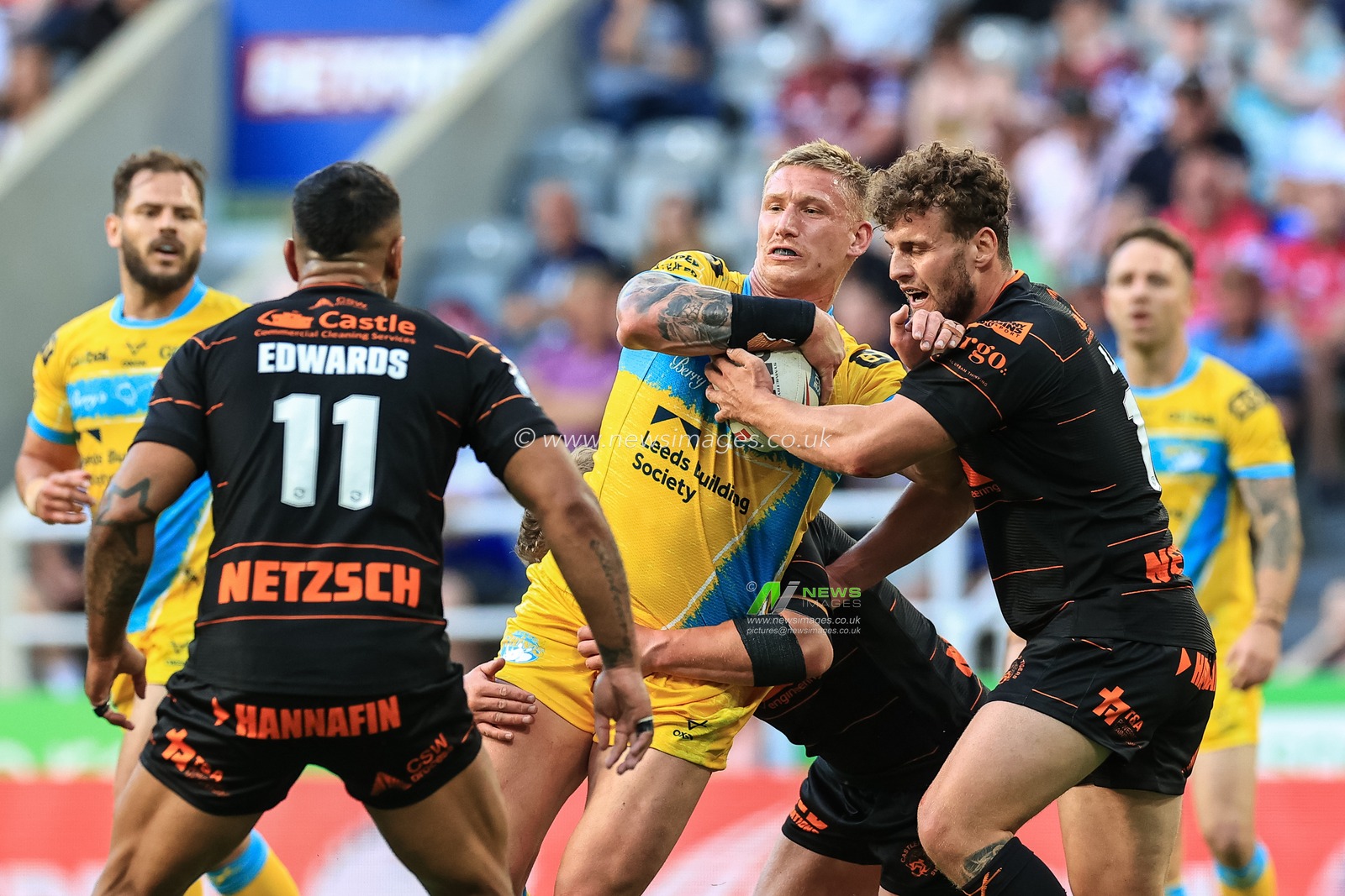 Mikolaj Oledzki #8 of Leeds Rhinos is tackled by George Lawler #10 of Castleford Tigers