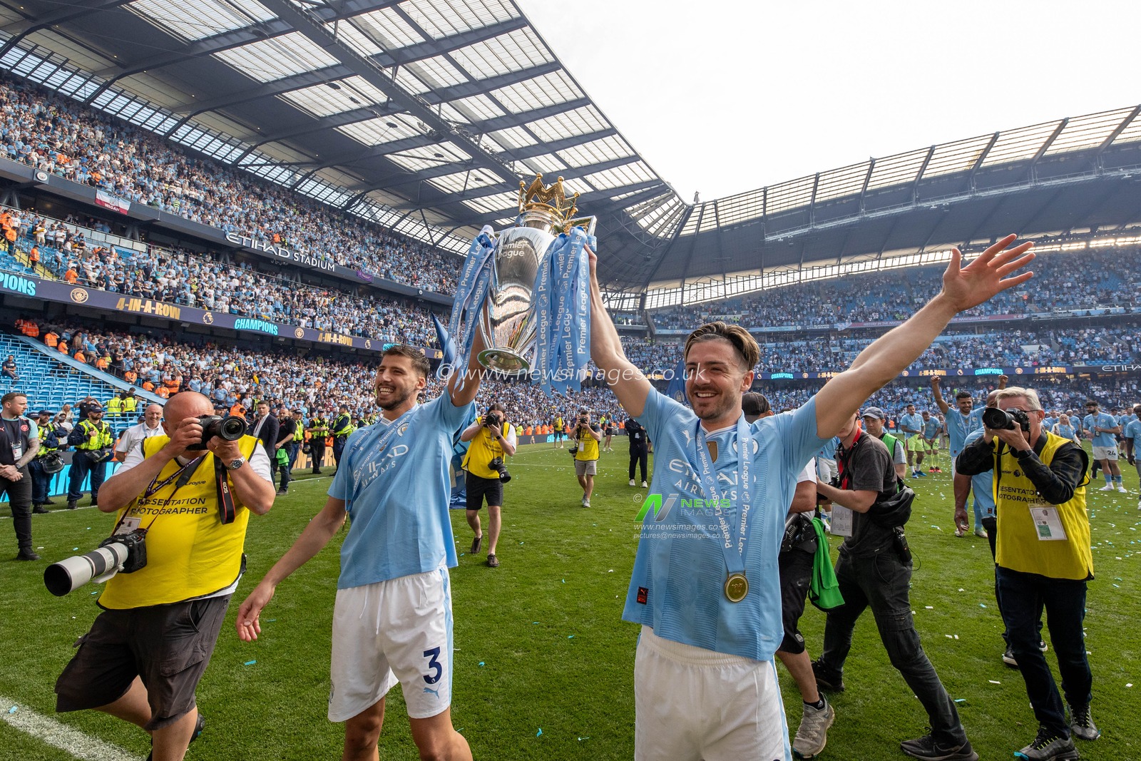 RÃºben Dias of Manchester City and Jack Grealish of Manchester City lift the Barclays Premier League trophy and celebrate in front of their supporters after the Premier League match Manchester City vs West Ham United at Etihad Stadium, Manchester, United Kingdom, 19th May 2024

(Photo by Mark Cosgrove/News Images)