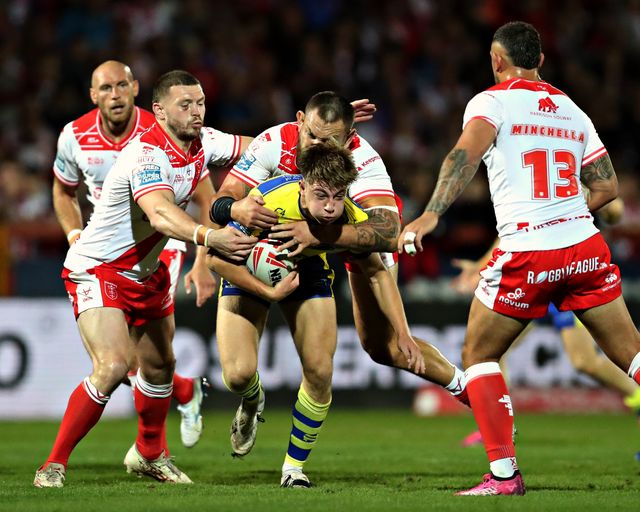 Ewan Irwin of Warrington Wolves is tackled by Jared Warea-Hargreaves of Hull KR and James Batchelor of Hull KR during the Betfred Super League round 27 match Hull KR vs Warrington Wolves at Sewell Group Craven Park, Kingston upon Hull, United Kingdom, 18th September 2025(Photo by Sam Eaden/News Images)