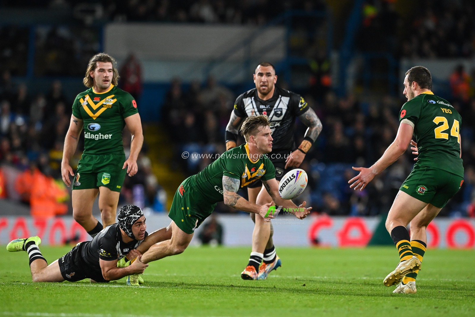 Cameron Munster of Australia offloads the ball despite the tackle of Jahrome Hughes of New Zealand during the Rugby League World Cup 2021 Semi Final match Australia vs New Zealand at Elland Road, Leeds, United Kingdom, 11th November 2022

(Photo by Craig Thomas/News Images)