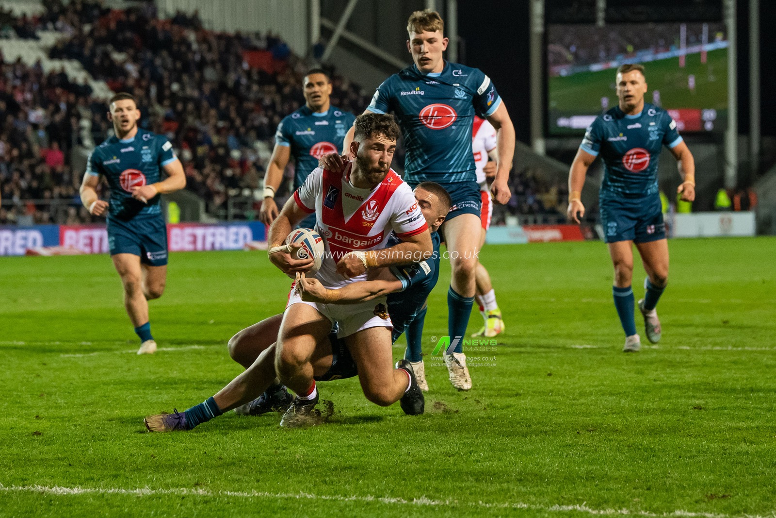 Sam Royal #22 of St Helens is tackled just short of the try line Danny Walker #16 of Warrington Wolves  by during the Betfred Super League match St Helens vs Warrington Wolves at Totally Wicked Stadium, St Helens, United Kingdom, 20th April 2023

(Photo by Craig Thomas/News Images)