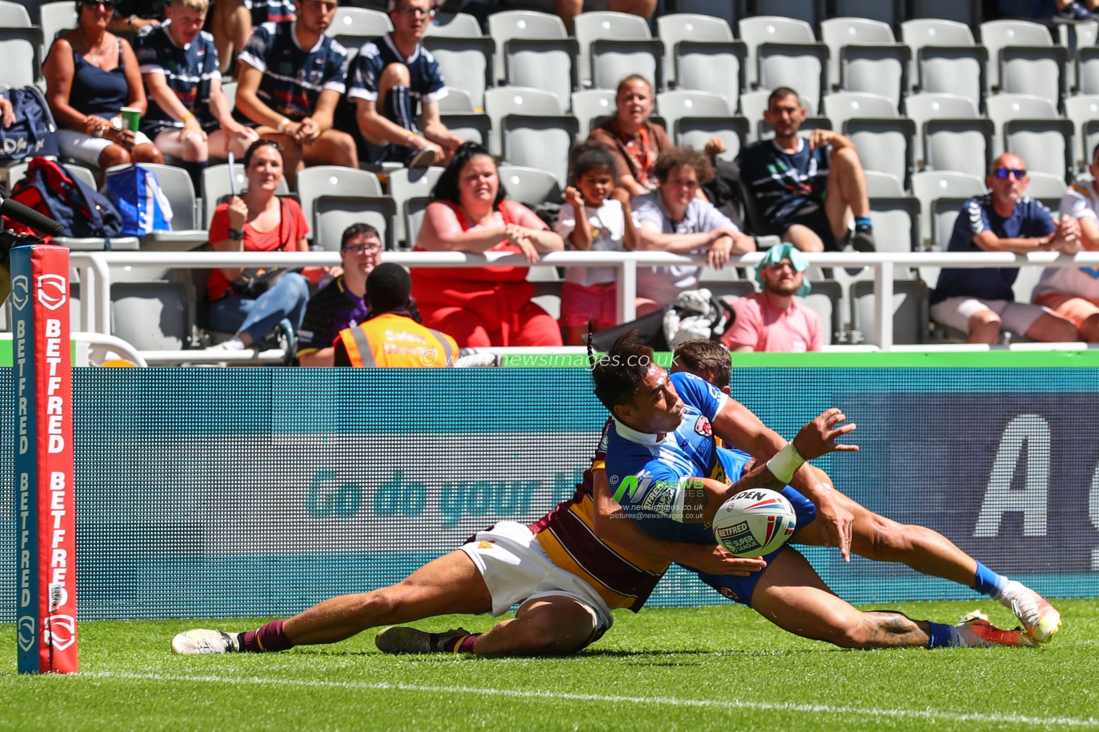 Innes Senior #25 of Huddersfield Giants tackles Ken Sio #2 of Salford Red Devils just short of the try line