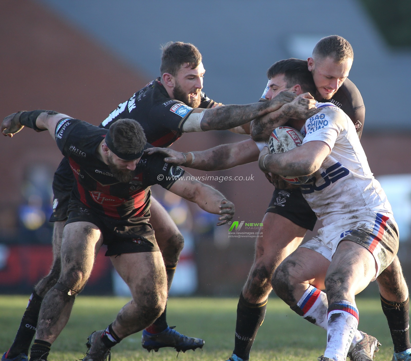 16th February 2020, Mobile Rocket Stadium, Wakefield, England; Betfred Super League, Wakefield Trinity v Warrington Wolves : Joe Arundel tackled around the head by Matt Davis, Daryl Clark and Ben Currie of Warrington Wolves.