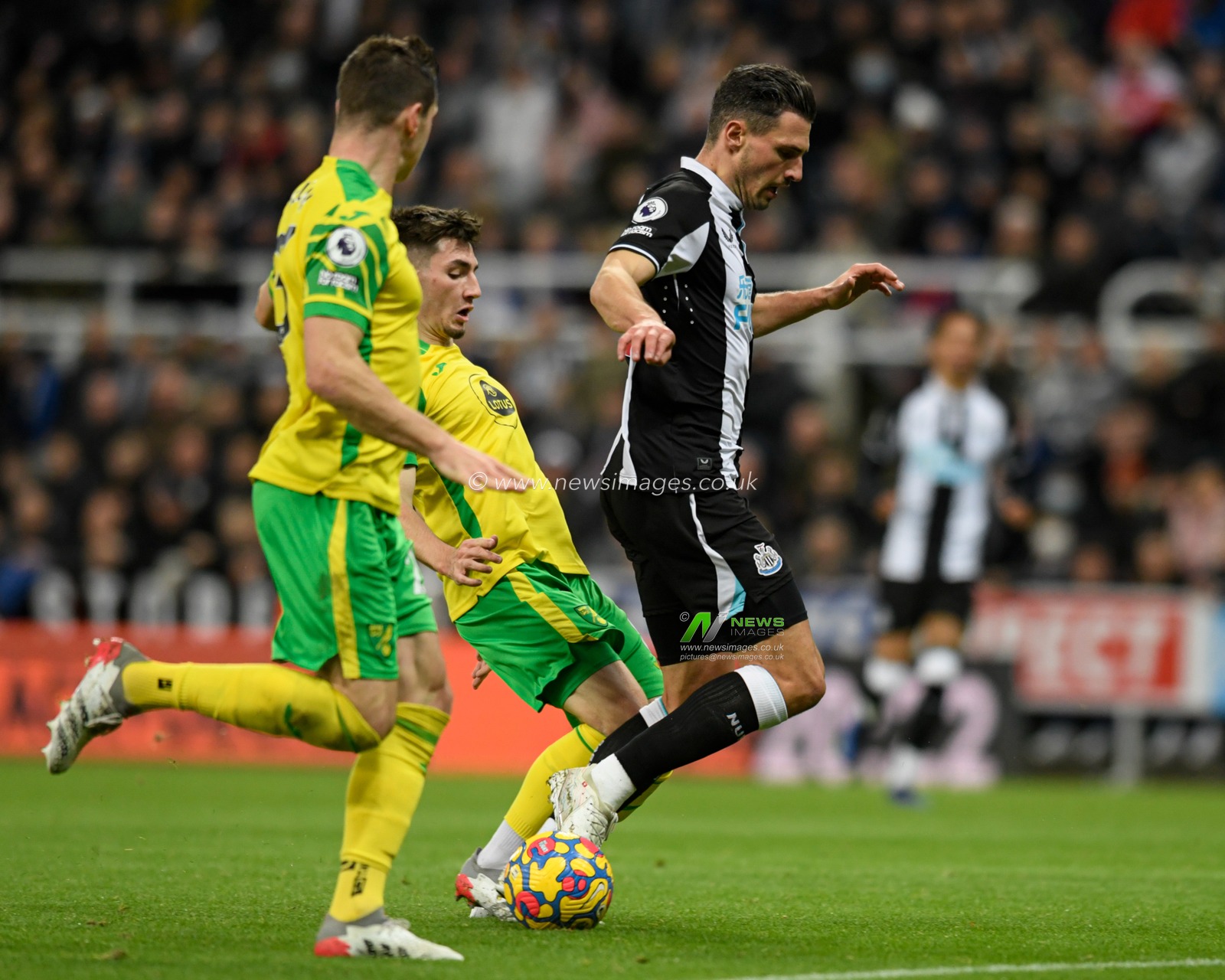 Billy Gilmour #8 of Norwich City tackles Fabian Schar #5 of Newcastle United on the edge of the penalty area