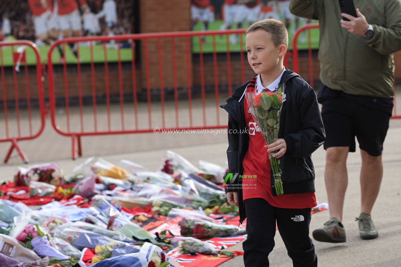 A young fan brings some flowers in tribute to the late Sir Bobby Charlton outside of Old Trafford, Manchester, United Kingdom, 23rd October 2023

(Photo by Conor Molloy/News Images)