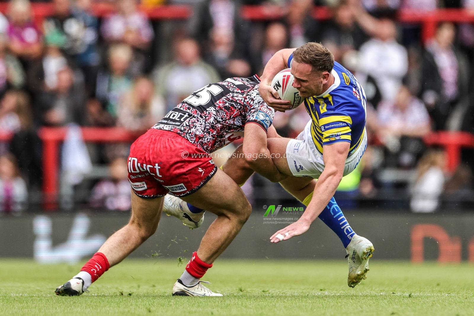 Ben Currie of Warrington Wolves is tackled by Louis Brogan of Leigh Leopards during the Betfred Super League round 20 match Leigh Leopards vs Warrington Wolves at Leigh Sports Village, Leigh, United Kingdom on 25 July 2026

(Photo by Alfie Cosgrove/News Images)