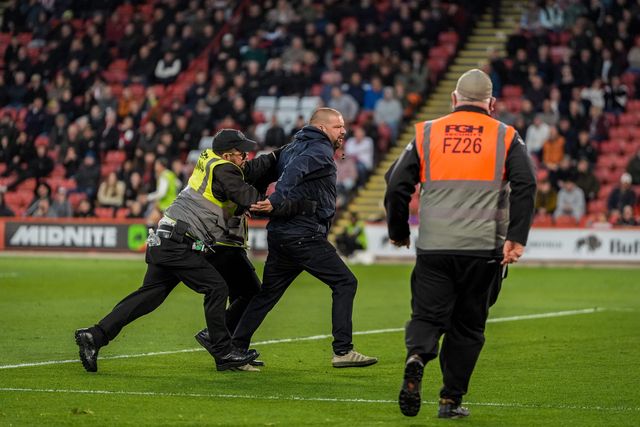 A pitch invader celebrates Yuki Ohashi of Blackburn Rovers scoring to make it 0-2 as security tries to remove him from the pitch during the Sky Bet Championship match Sheffield United vs Blackburn Rovers at Bramall Lane, Sheffield, United Kingdom on 22 April 2026

(Photo by Maynard Manyowa/News Images)