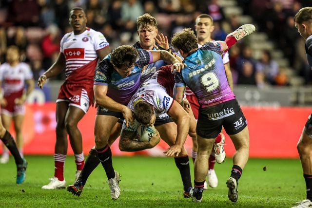 Kaide Ellis of Wigan Warriors is tackled by Harvie Hill of Hull FC and Amir Bourouh of Hull FC during the Betfred Super League match Wigan Warriors vs Hull FC at The Brick Community Stadium, Wigan, United Kingdom on 21 February 2026

(Photo by Alfie Cosgrove/News Images)