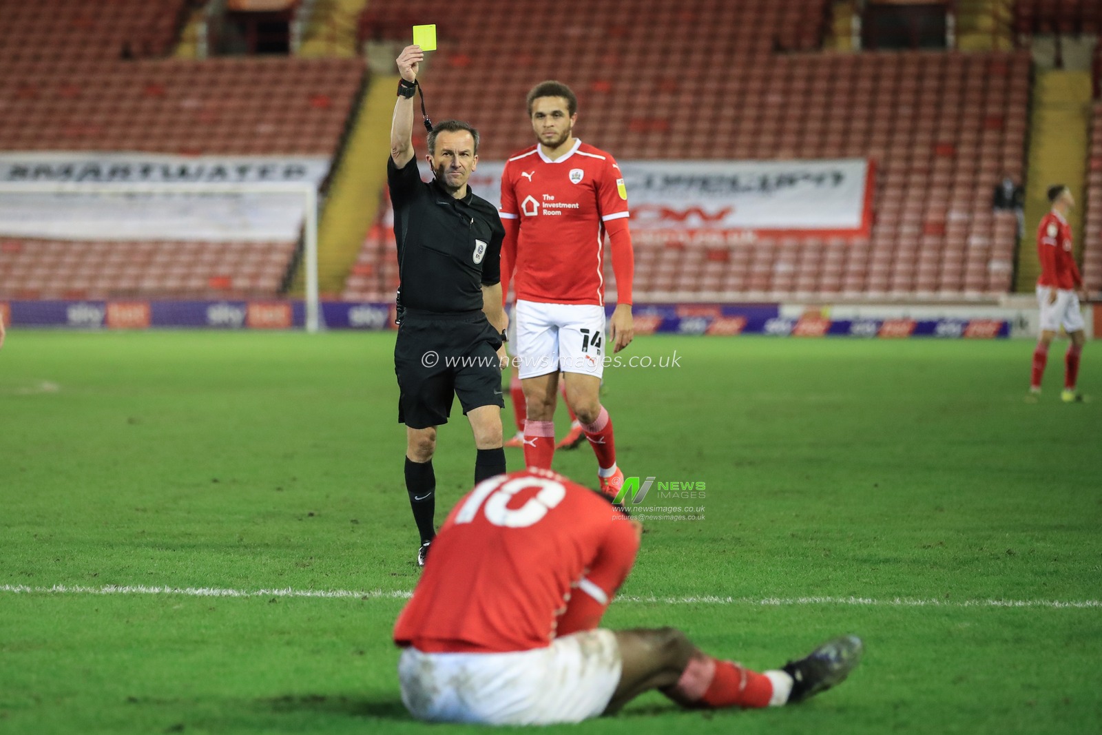 Referee Keith Stroud gives Daryl Dike #10 of Barnsley a yellow card for going down in the Derby area