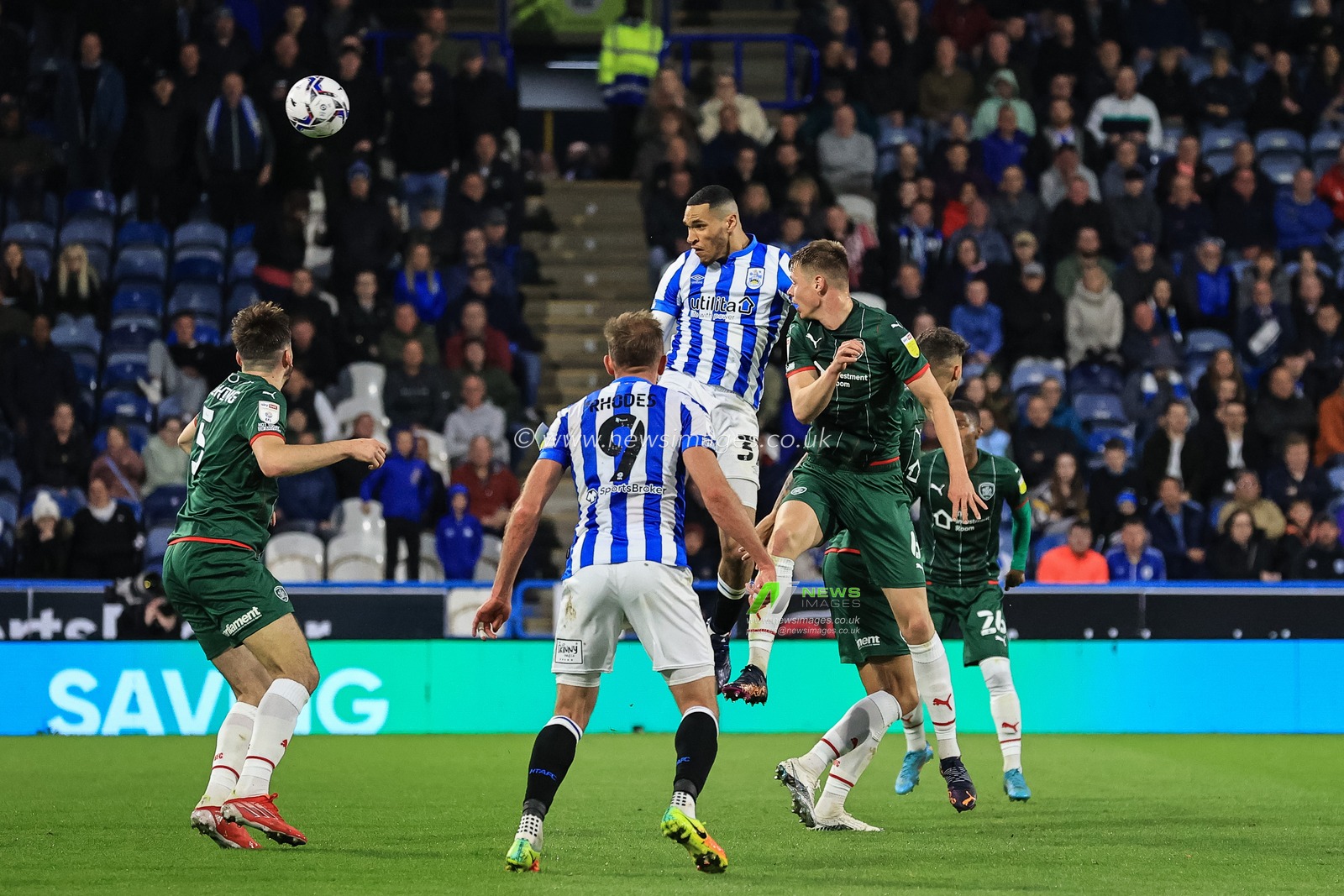 Jon Russell #37 of Huddersfield Town heads on goal, saved by Jack Walton #1 of Barnsley