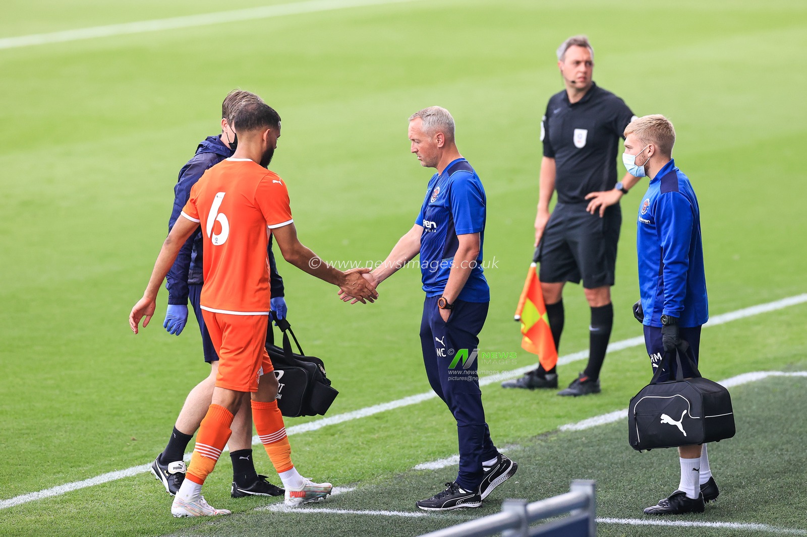 Neil Critchley manager of Blackpool shakes hands with Kevin Stewart of Blackpool as he leaves the pitch with an injury