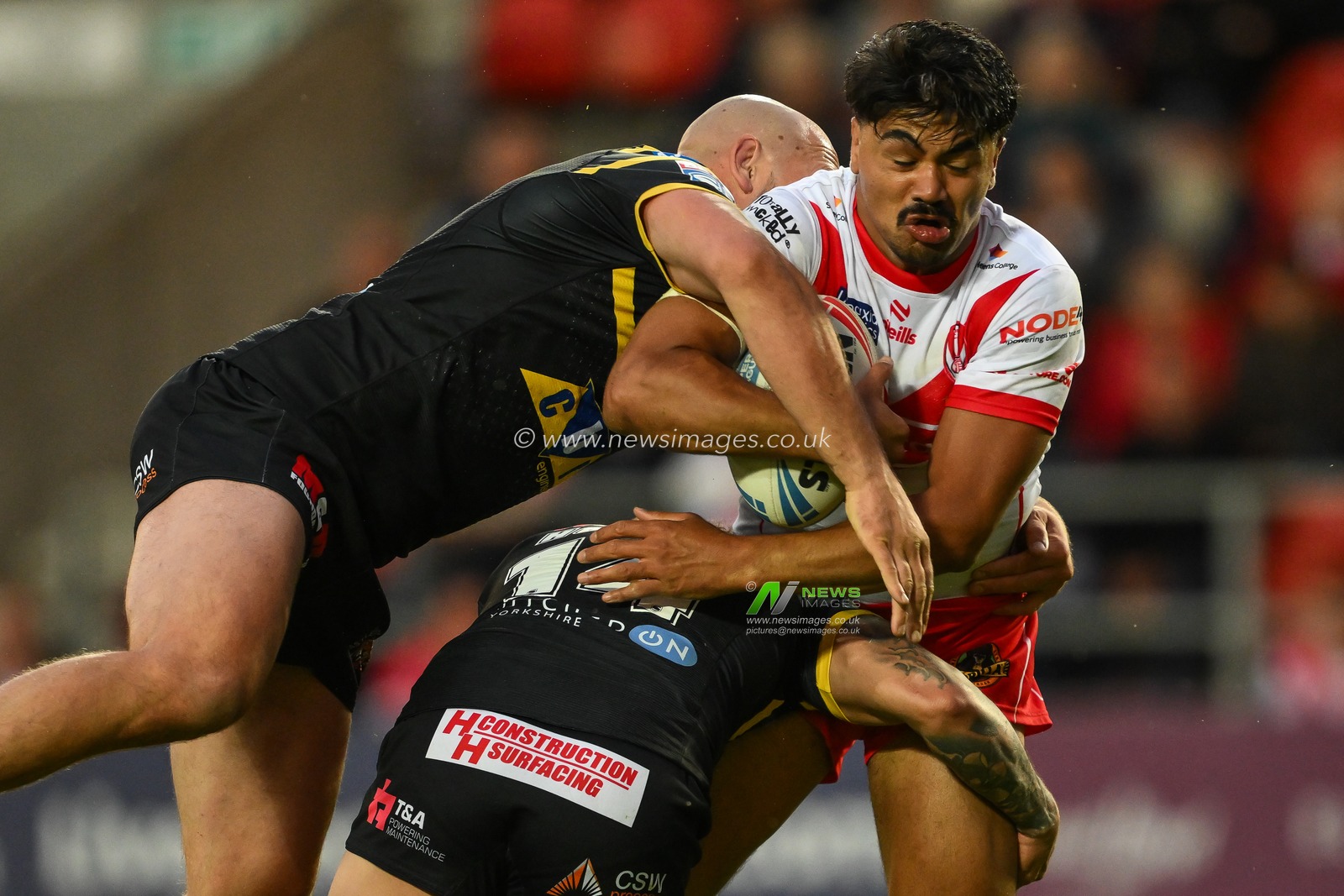 James Bell of St. Helens is tackled by Liam Watts of Castleford Tigers and Liam Horne of Castleford Tigers during the Betfred Super League Round 16 match St Helens vs Castleford Tigers at Totally Wicked Stadium, St Helens, United Kingdom, 5th July 2024

(Photo by Craig Thomas/News Images)