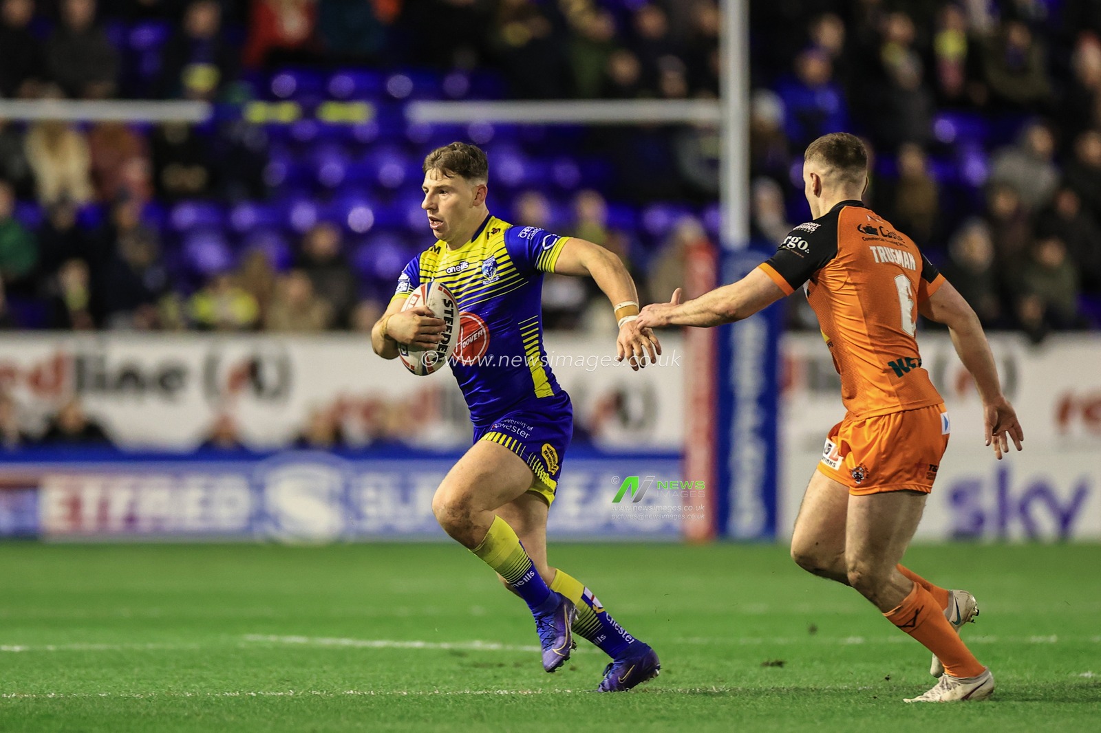 George Williams #7 of Warrington Wolves breaks free and makers a run from Jake Trueman #6 of Castleford Tigers