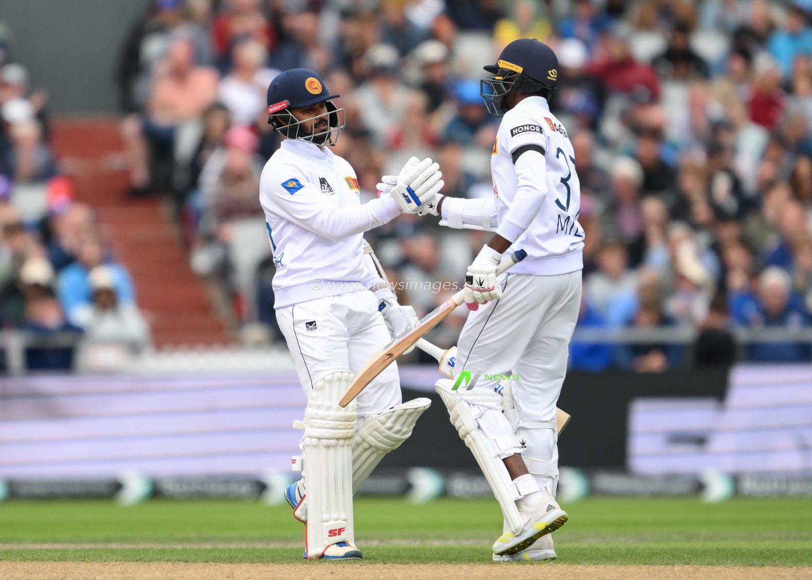 Milan Rathnayake of Sri Lanka congratulates Dhananjaya de Silva of Sri Lanka on his half century of fifty runs during the England Men v Sri Lanka 1st Rothesay Test Match at Old Trafford, Manchester, United Kingdom, 20th August 2024

(Photo by Craig Thomas/News Images)