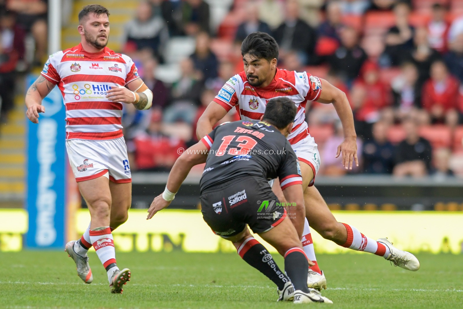 James Bell (13) of Leigh Centurions looks to run past Elijah Taylor (13) of Salford Red Devils