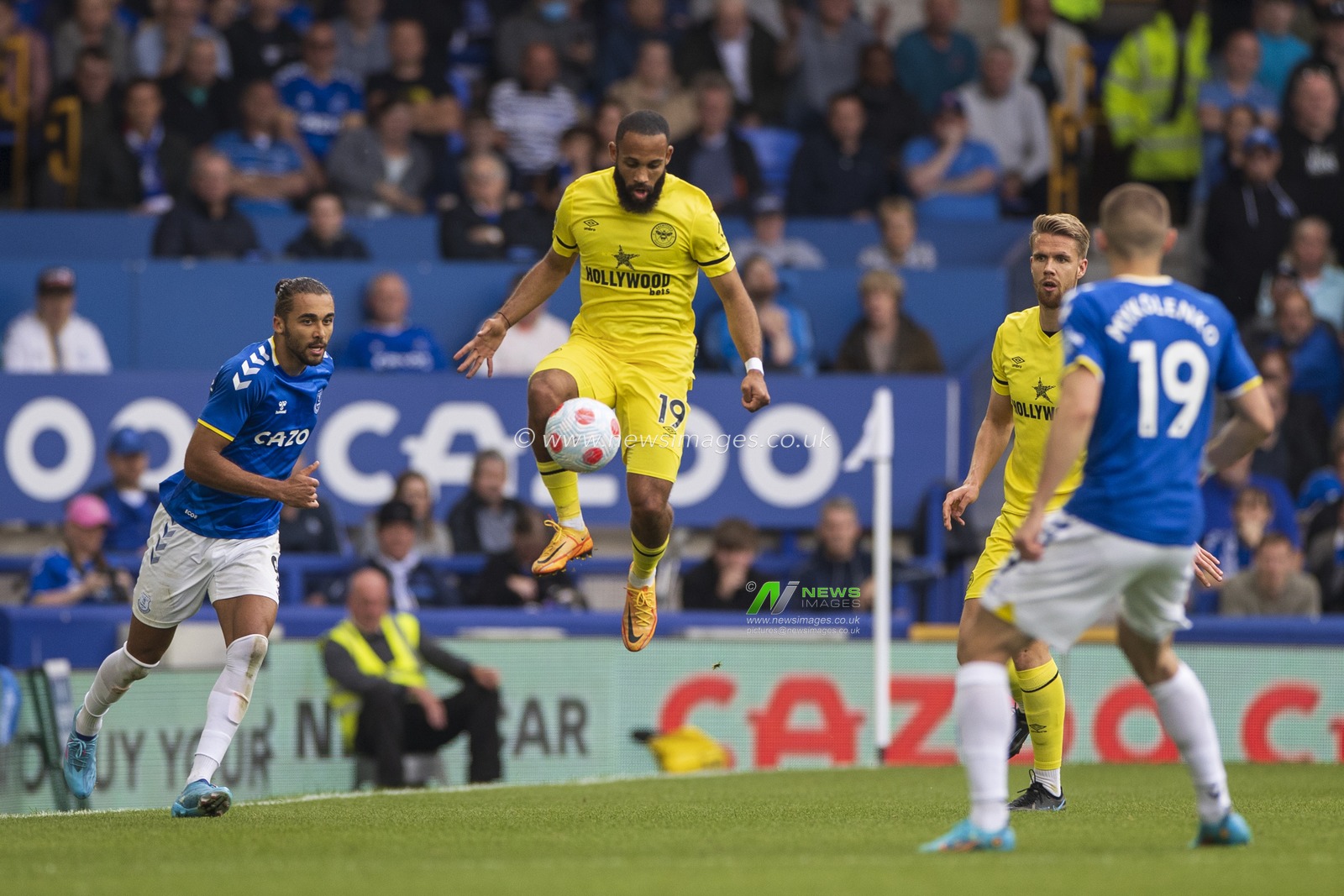Bryan Mbeumo #19 of Brentford controls the ball in mid air watched by Dominic Calvert-Lewin #9 of Everton