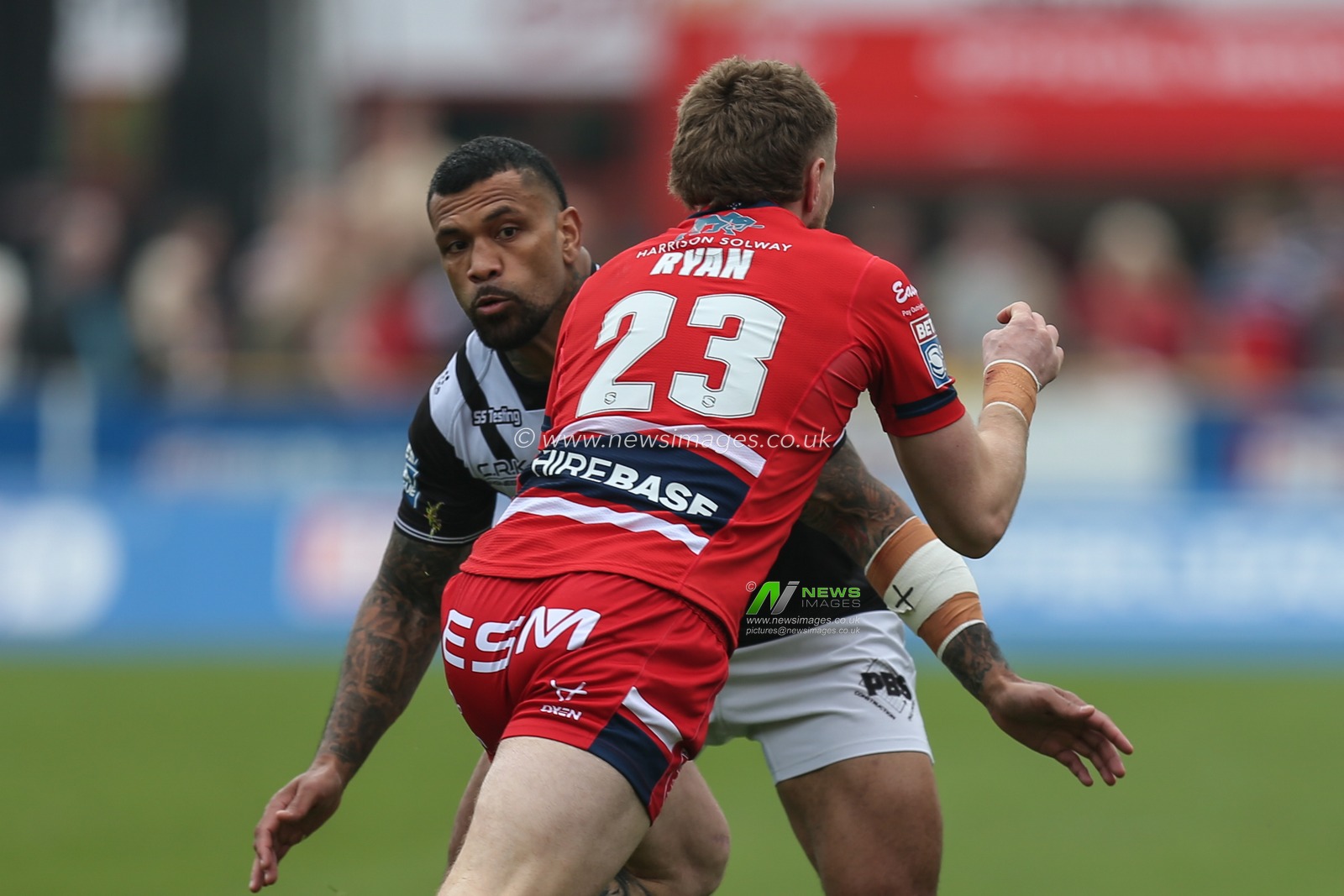 Manu Ma'u #12 of Hull FC looks to stop Ethan Ryan #23 of Hull KR