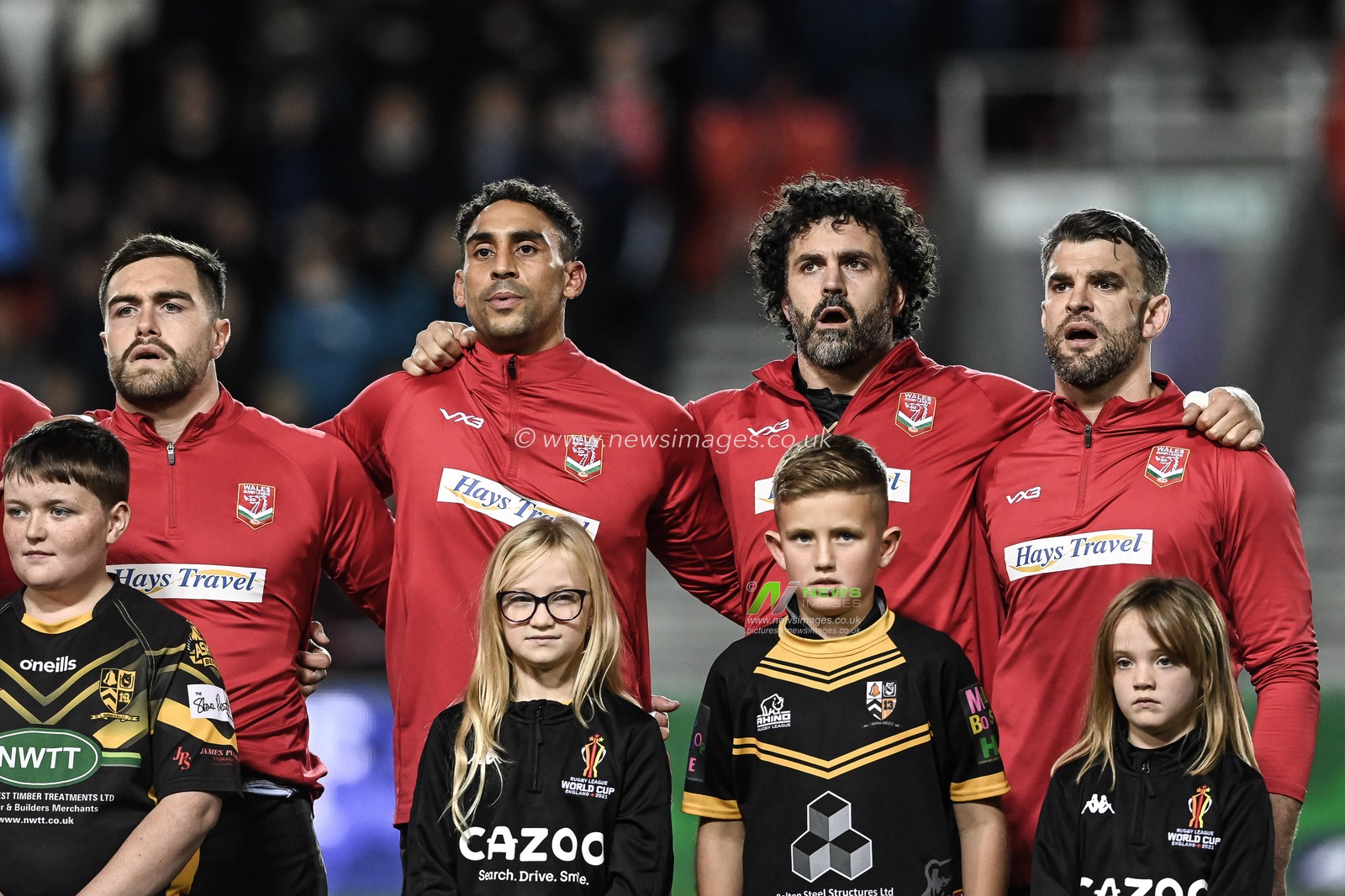 Matty Fozard, Dalton Grant, Rhys Williams and Elliot Kear of Wales during Welsh National  Anthem ahead of the Rugby League World Cup 2021 match Tonga vs Wales at Totally Wicked Stadium, St Helens, United Kingdom, 24th October 2022

(Photo by Craig Thomas/News Images)