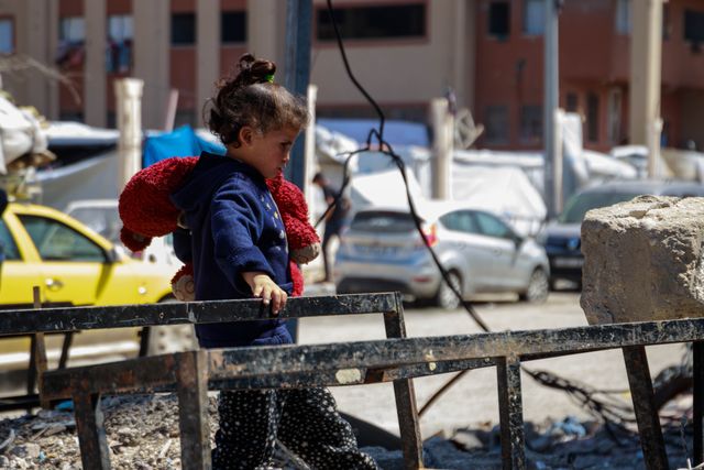 Between the rubble, on a burnt-out school desk, a little girl plays with her doll, which was torn apart by Israeli aircraft on the side of the street, after fleeing death from the northern Gaza Strip to the western Gaza City.(Photo: Mohammed Skaik/News Images)