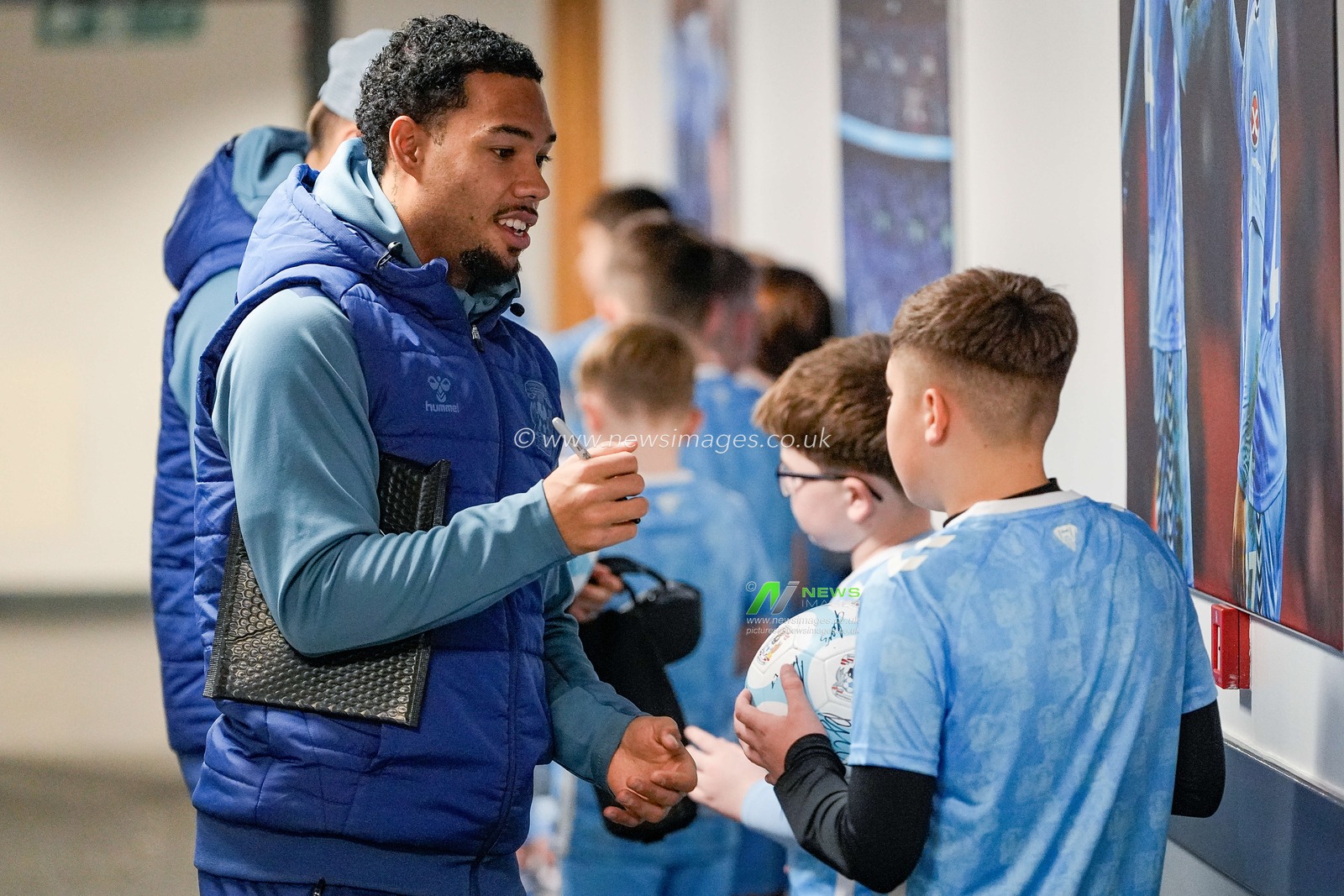 Milan van Ewijk, of Coventry City signs a ball for mascots during the Sky Bet Championship match Coventry City vs Swansea City at Coventry Building Society Arena, Coventry, United Kingdom, 26th December 2025

(Photo by Maynard Manyowa/News Images)

*** GER AUT SUI OUT ***