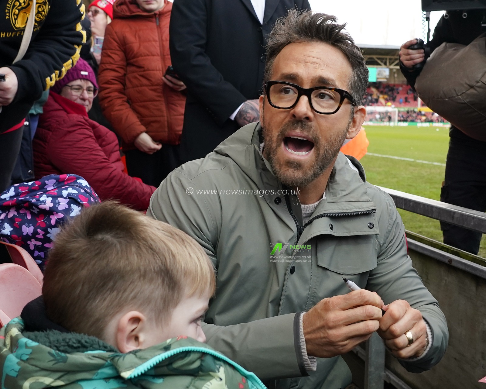 Wrexham co-owner Ryan Reynolds signs an autograph for a young fan before the Emirates FA Cup fourth round match Wrexham vs Sheffield United at The Racecourse Ground, Wrexham, United Kingdom, 29th January 2023

(Photo by Steve Flynn/News Images)
