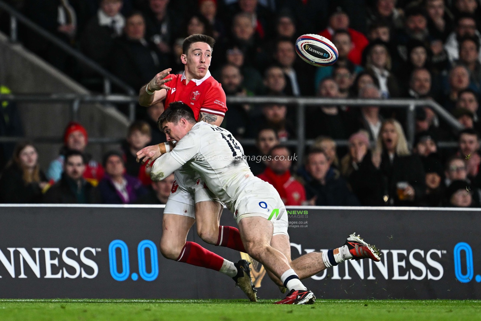 Josh Adams of Wales off loads the ball despite the tackle of Tommy Freeman of England during the 2024 Guinness 6 Nations match England vs Wales at Twickenham Stadium, Twickenham, United Kingdom, 10th February 2024

(Photo by Craig Thomas/News Images)