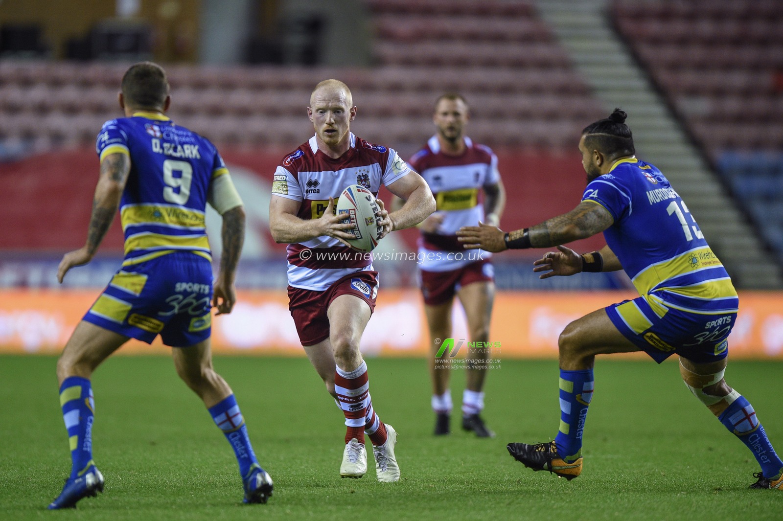 16th August 2019 , DW Stadium, Wigan, England;  Betfred Super League, Round 26, Wigan Warriors vs Warrington Wolves ; Liam Farell of Wigan Warriors in attack ahead of Ben Murdoch-Masila of Warrington Wolves and Daryl Clark of Warrington Wolves 

Credit: Richard Long/News Images