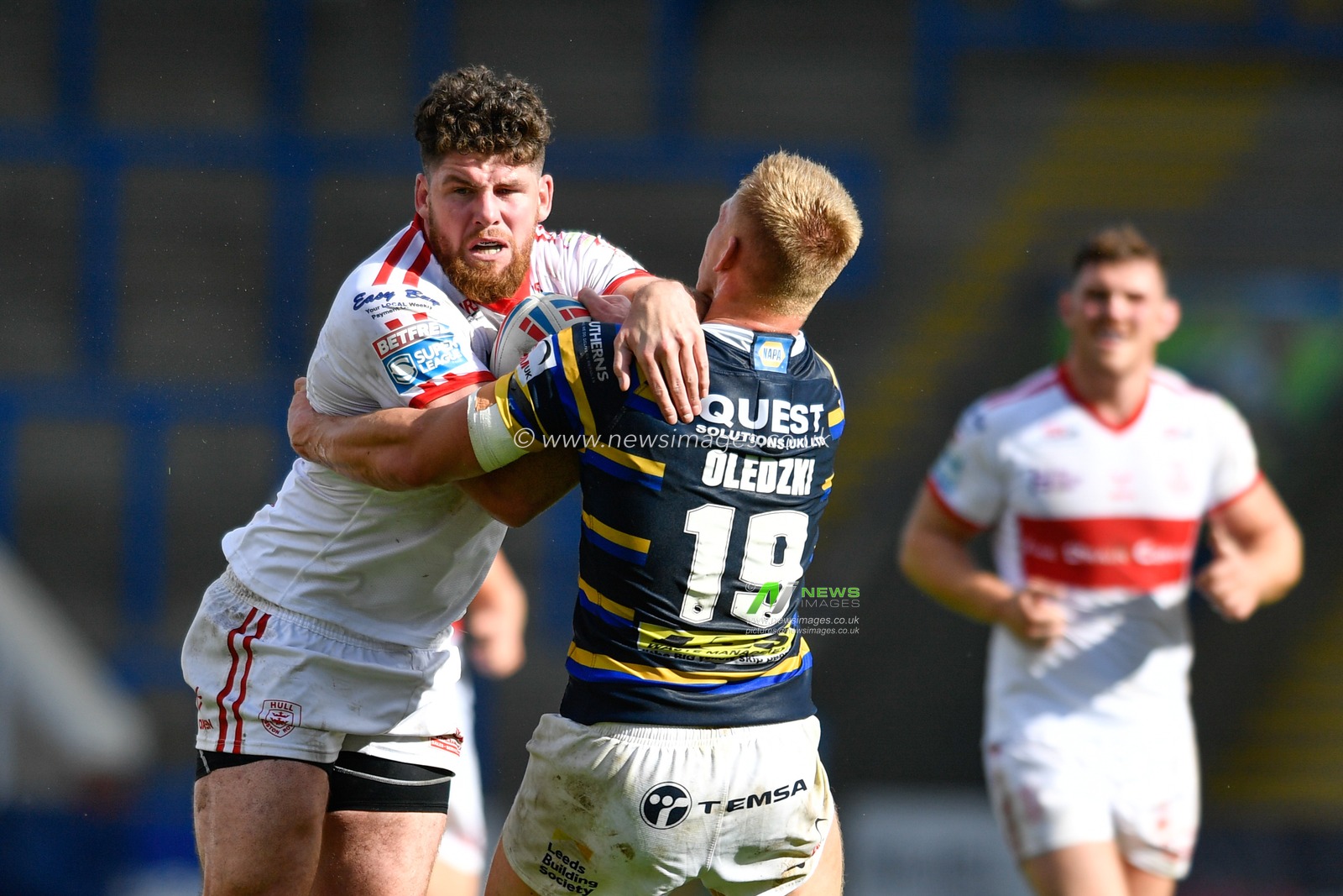 Mitch Garbutt (14) of Hull KR is tackled by Mikolaj Oledzki (19) of Leeds Rhinos