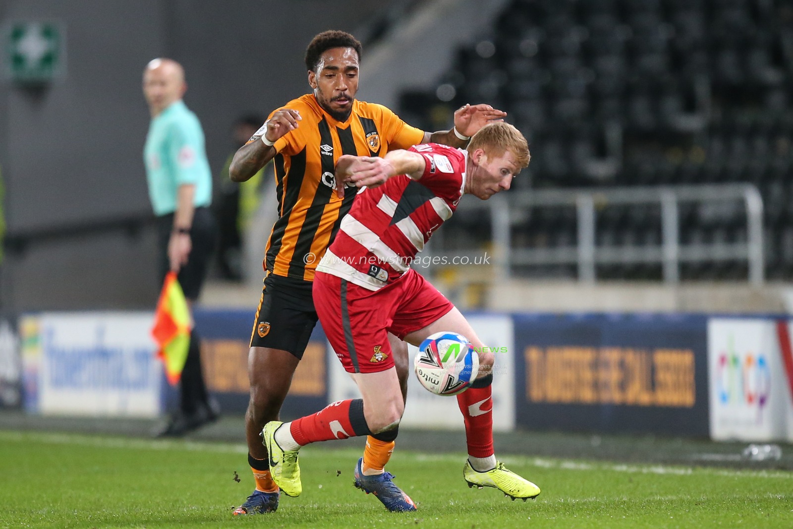 Mallik Wilks #7 of Hull City and Brad Halliday #2 of Doncaster Rovers challenge for the ball