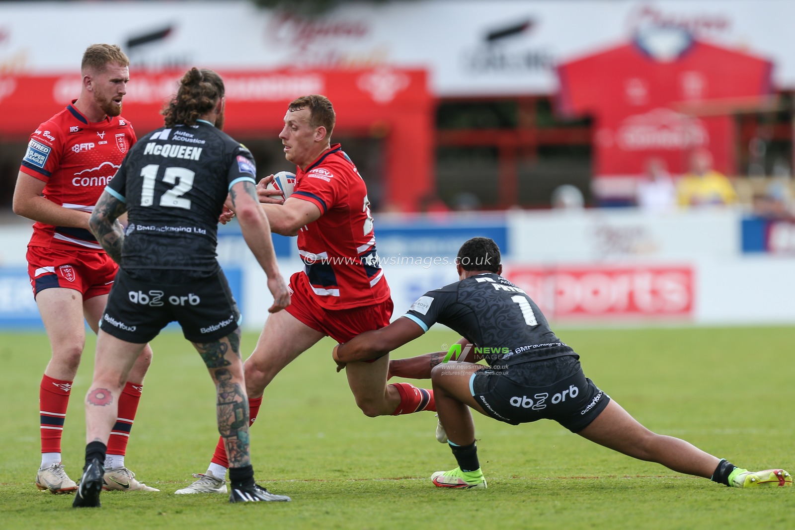 Frankie Halton #27 of Hull KR tries to get past Will Pryce #1 of Huddersfield Giants