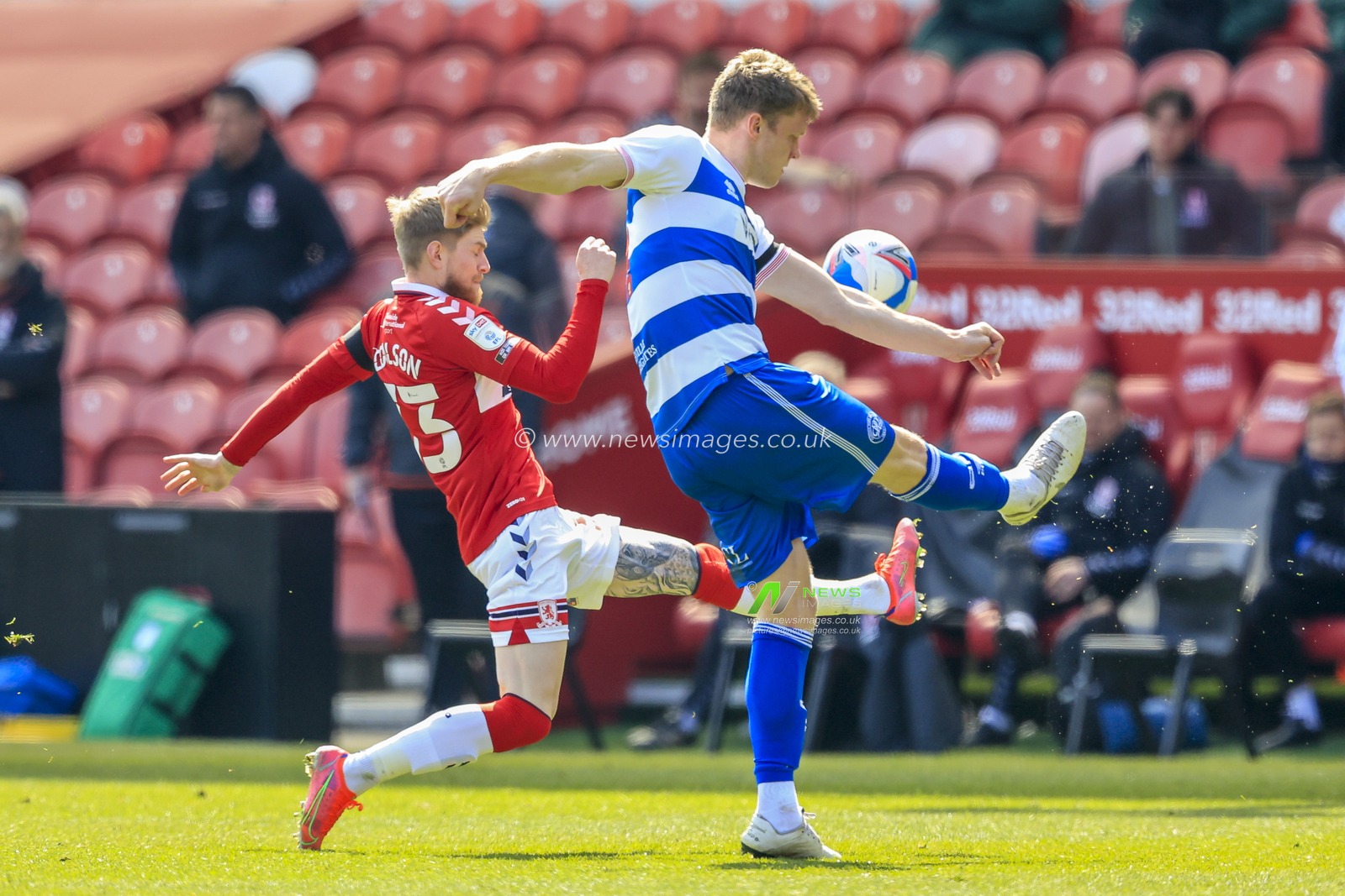 Rob Dickie #4 of Queens Park Rangers kicks the ball upfield under pressure from Hayden Coulson #33 of Middlesbrough