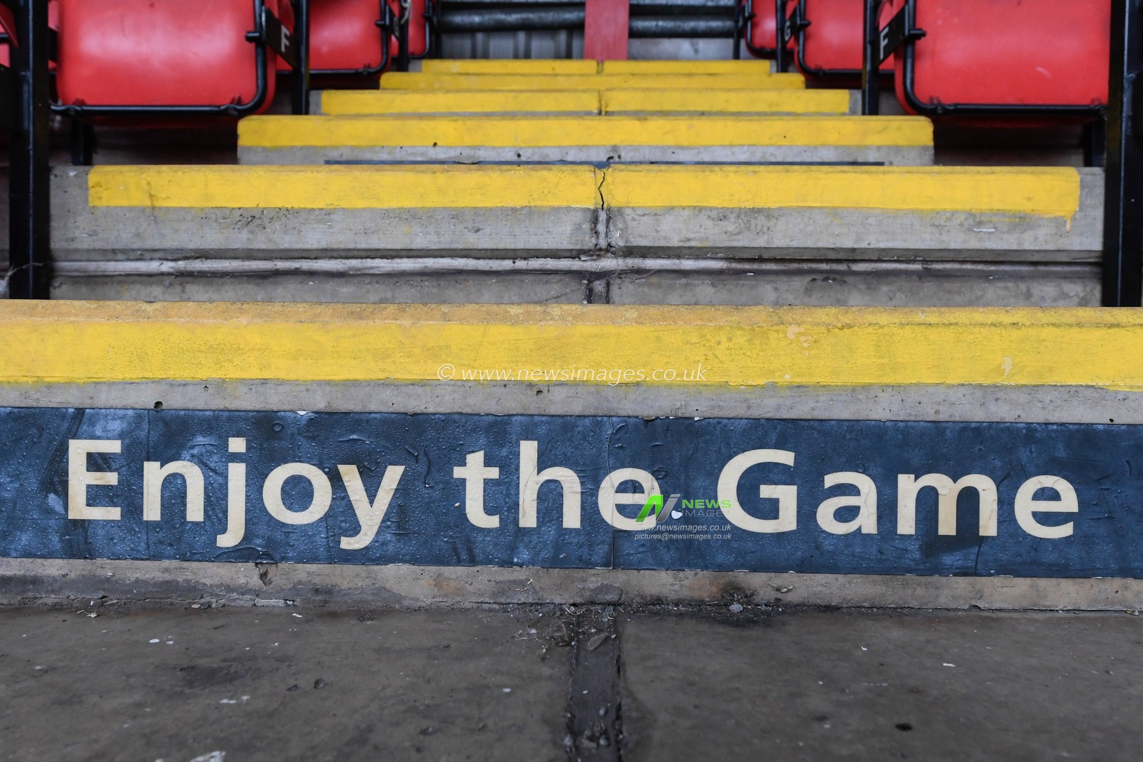 An enjoy the game sign in the spectator stand at the Alexandra Stadium