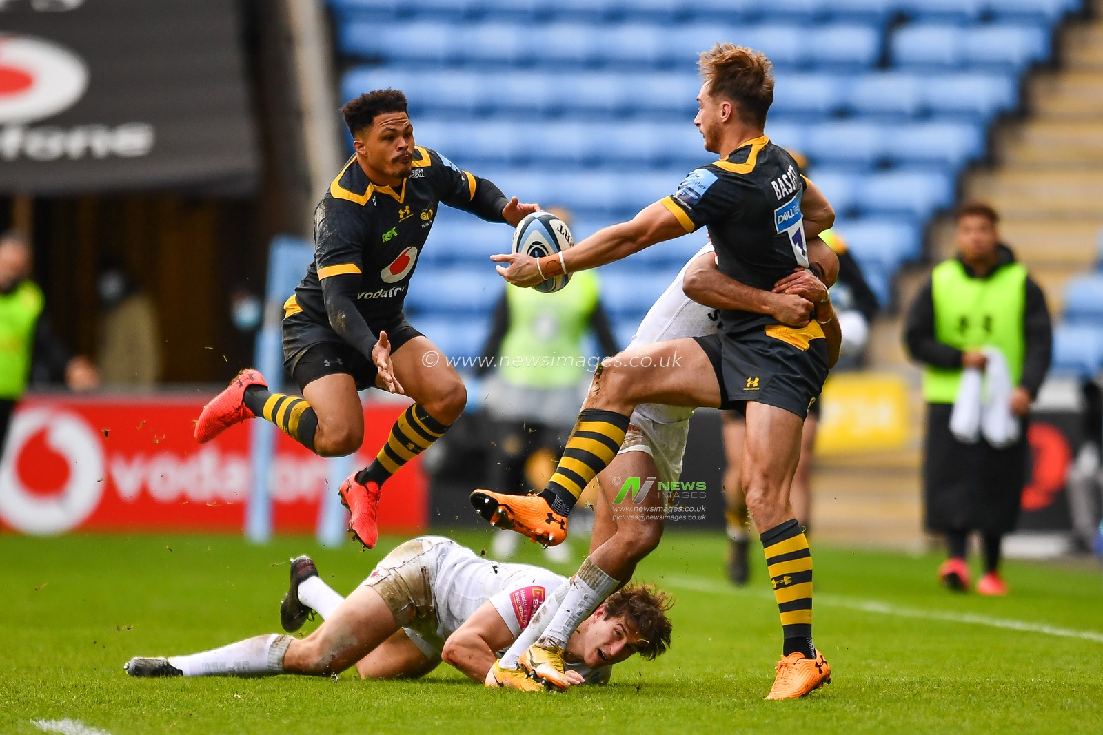 Josh Bassett of Wasps offloads in the tackle to team mate Juan de Jongh