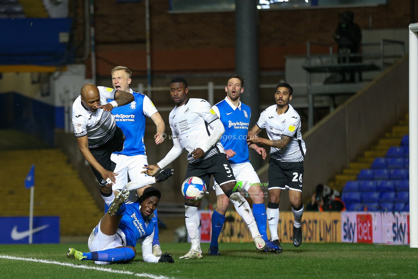 Jonathan Leko #14 of Birmingham City takes a shot whilst under pressure from Andre Ayew #10 of Swansea City